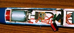 Installation of the author's high rate speed control with brake in the nose of a modified Great Planes Spectra. Again, notice the fuse in the positive battery lead. The motor is a Great Planes Goldfire, reworked with a car motor end-bell and replaceable brushes, turning a Master Airscrew 12x8 folding propeller through a 2.5:1 gearbox. Current draw is about 30A, and the speed control barely gets warm.