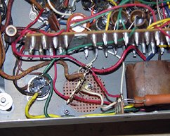 The capacitors and internal wiring are connected to a 4-position solder terminal strip.