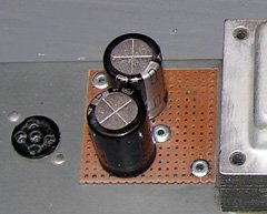 The new capacitors were neatly mounted on a piece of perfboard riveted to the amplifier chassis.