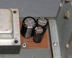 Three of the four replacement capacitors are on top of the chassis and the fourth is underneath.