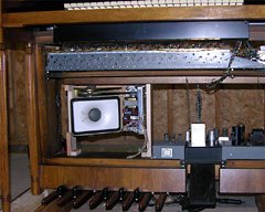 Speaker assembly screwed to back of frame, viewed from the front.