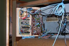 Plywood mounting board with circuitry installed on the right hand wall of the organ, with wires leading to the front.