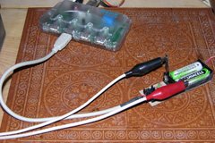 For initial tests, I used a USB hub for power. A pair of #11 hobby knife blades between the cells and the contacts let me hook up a voltage monitor.