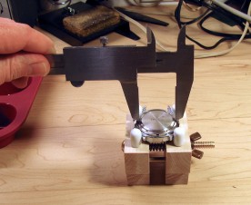 With the watch secured in a case holder, an inexpensive steel caliper makes a workable case back opening tool.