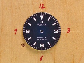 The dial holding block, precisely marked for artwork alignment.