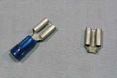 Two female spade connectors that will be turned into a simple fuse holder. One has had its sleeve cut off already.