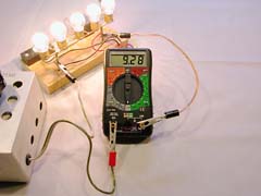 To measure currents (up the the multimeter's 10 Amp limit), short heavy duty leads are connected to the "10A" and "COM" terminals. These five automotive light bulbs in parallel draw 9.28A from a 7-cell CP2400SCR pack (not visible).