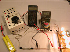 Using one meter to measure current (the left one), the other meter's alligator clips are positioned on the shunt until it reads the same number of milliVolts as there are Amps flowing. This calibrates the shunt. The aluminum box is my bench-top "speed control", but here is just being used to connect the battery to the circuit.