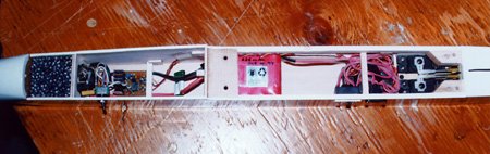 Equipment installation. From left to right: lead weight, back of motor, arming switch, home-made ESC with brake, 30A fuse, front wing hold-down block, 600mAh receiver pack, receiver and switch harness, servos, and rear wing hold-down blocks.