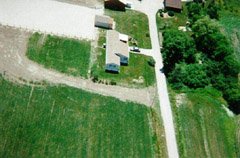 Here's a view of the mobile home and shed looking south, from about 500ft. You can see the end of the barn at the top of the photo. I'm visible at the left side, half way down the photo. The large whitish area is our riding/driving ring.