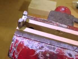 End link clamped in a hardwood-jawed vice for filing.