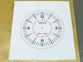 The printed dial artwork, epoxied to 1/16″ (1.6mm) plywood.
