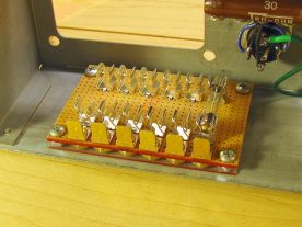 The fuse holder is fastened to the chassis with four 6-32 bolts and nuts.