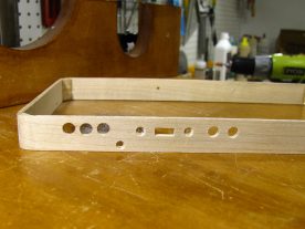 Completed holes along the top edge of the case, including countersunk screw holes.